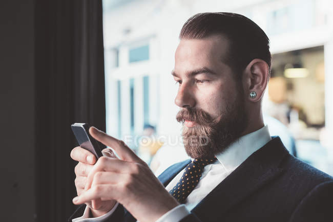 Empresário ler atualização smartphone no café — Fotografia de Stock