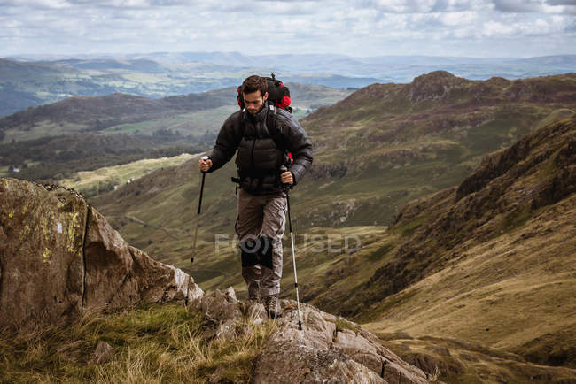 Senderista joven subiendo la montaña, The Lake District, Cumbria, Reino Unido - foto de stock