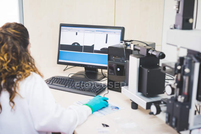 Female scientist analyzing obtained contact angle data — Stock Photo