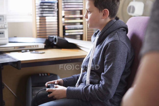 Niño usando el control para el juego de ordenador - foto de stock