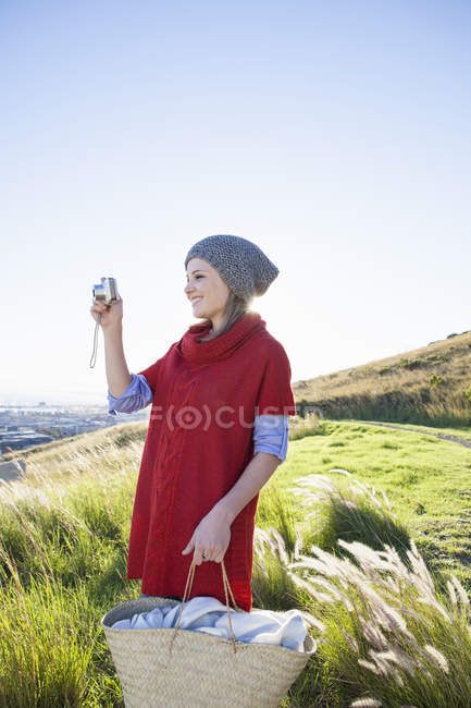 Young woman photographing view from hill — Stock Photo