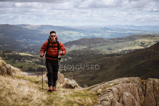Young male hiker hiking up mountain, The Lake District, Cumbria, UK — Stock Photo