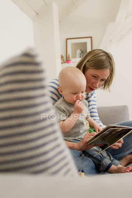 Maturo madre e figlia bambino lettura libro di fiabe sul divano salotto — Foto stock