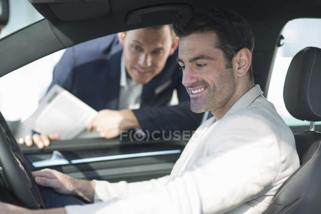 Customer trying out new car in car dealership — Stock Photo