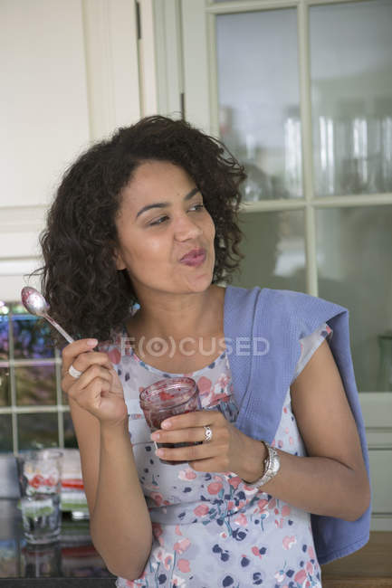 Metà donna adulta in cucina, mangiare dolcetto — Foto stock