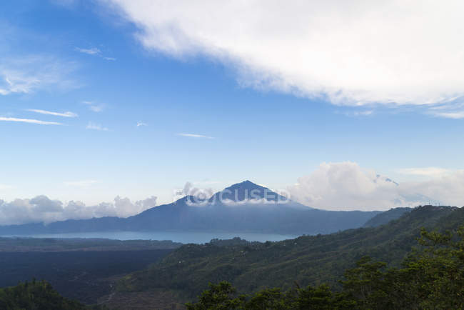 Vista panorámica de la montaña volcánica bajo el cielo azul - foto de stock