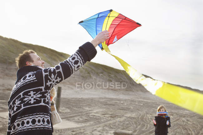 Mid adult man and son preparing to fly kite on beach, Bloemendaal aan Zee, Netherlands — Stock Photo