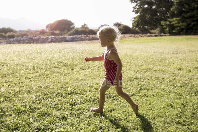Bambino femmina che corre in campo — Foto stock