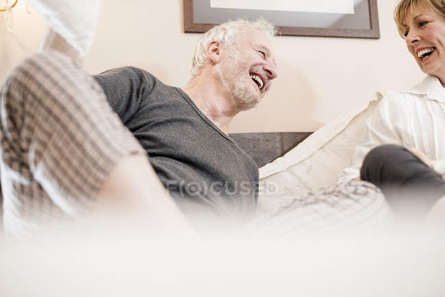 Pareja riendo en la cama, enfoque diferencial - foto de stock