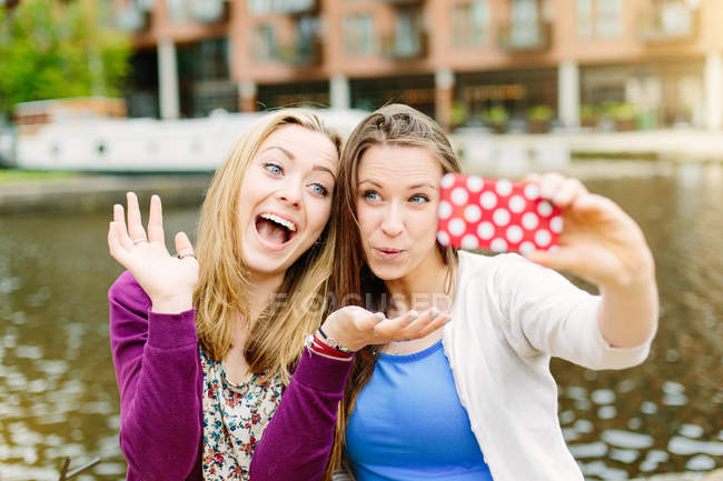 Жінки друзі беруть селфі на воді каналу — стокове фото