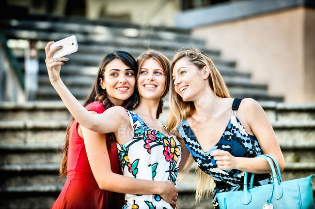 Three fashionable young women taking selfie on stairway, Cagliari, Sardinia, Italy — Stock Photo