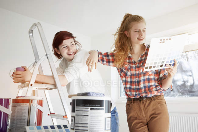 Due sorelle adolescenti che si preparano a decorare la camera da letto — Foto stock