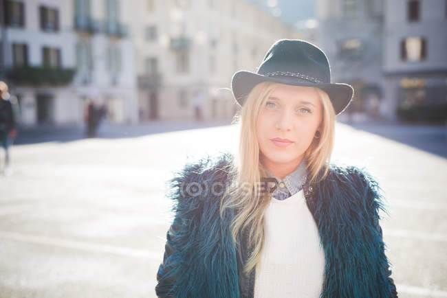 Retrato de jovem mulher usando chapéu fedora na praça da cidade — Fotografia de Stock