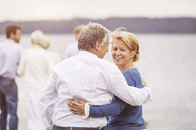 Group of friends standing walking along pier, rear view — Stock Photo