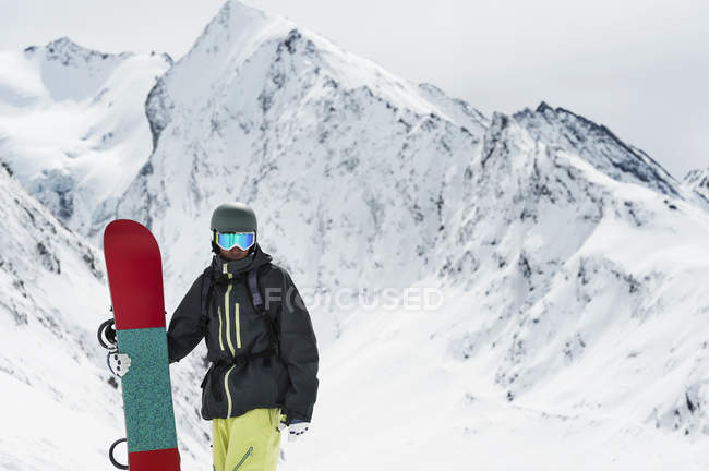Junger männlicher Snowboarder posiert mit Board, Obergurgl, Österreich — Stockfoto