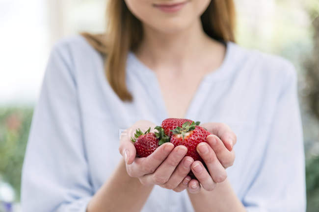 Woman with hands cupped holding strawberries — Stock Photo