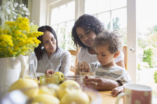 Familia de tres generaciones desayunando juntos - foto de stock