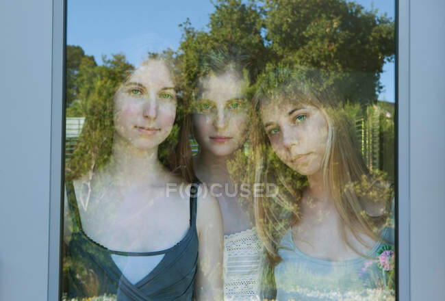 Девушки смотрят через стеклянную дверь — стоковое фото