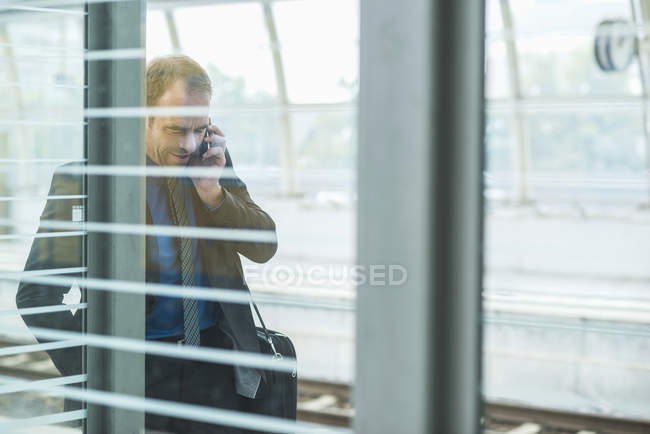 Mature man in suit talking cell phone — Stock Photo
