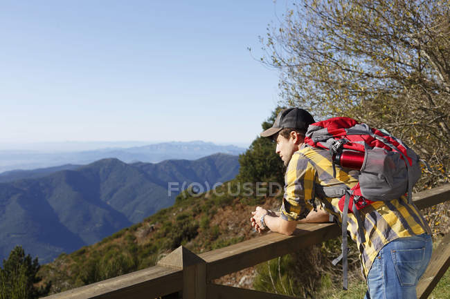 Hiker looking over valley against wooden handrail, Montseny, Barcelona, Catalonia, Spain — Stock Photo