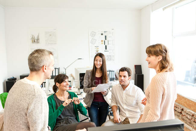 Colleagues in office discussing paperwork smiling — Stock Photo