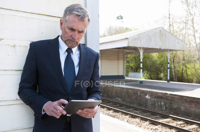 Empresario usando tableta digital en plataforma ferroviaria - foto de stock