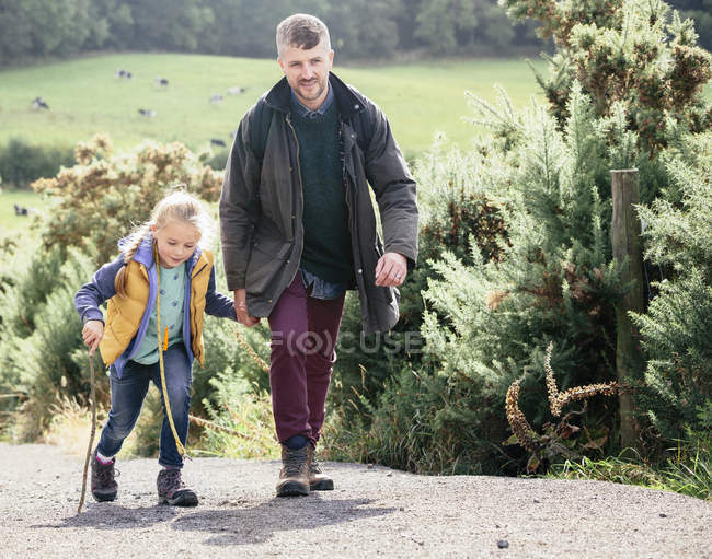 Padre e figlia escursionismo su strada rurale in campagna — Foto stock