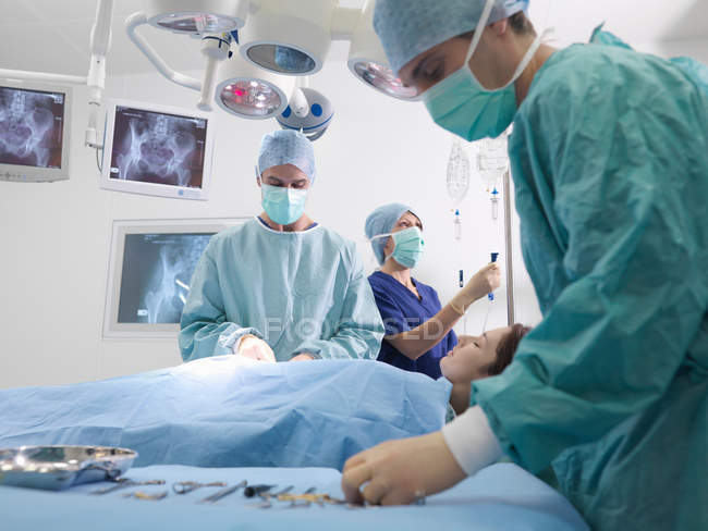 Cirujano y enfermeras realizando cirugía - foto de stock