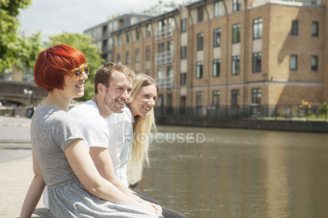 Amigos sentados no lado do canal, Londres, Reino Unido — Fotografia de Stock