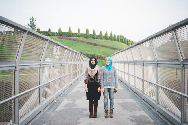 Porträt zweier junger Freundinnen auf Parksteg — Stockfoto