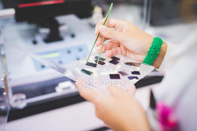 Female scientist using FTIR spectrophotometer, taking thin film sample for measurement — Stock Photo