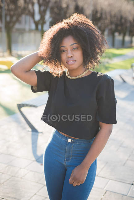 Portrait of young woman with hand in hair in park — Stock Photo