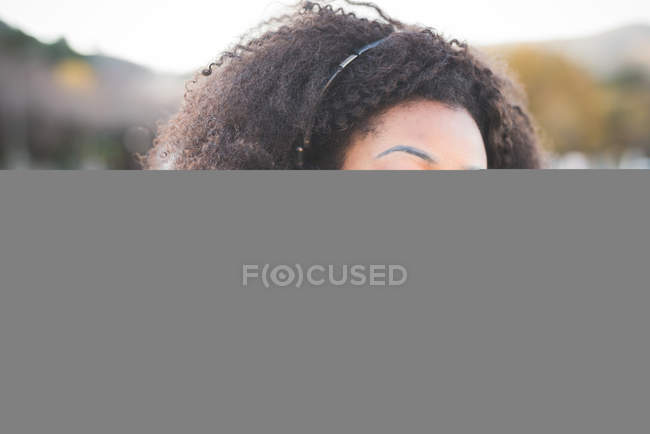 Close up of young woman listening to headphones with eyes closed at Lake Como, Italy — Stock Photo