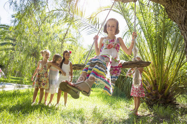 Meninas em fila para árvore balançar no jardim — Fotografia de Stock