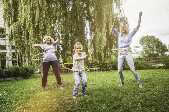 Familienmitglieder spielen mit Hula-Hoop-Reifen — Stockfoto
