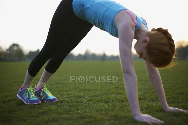 Portrait de femme s'échauffant pour faire de l'exercice dans le parc — Photo de stock