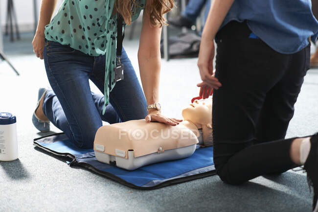 College student performing CPR on mannequin in class — Stock Photo