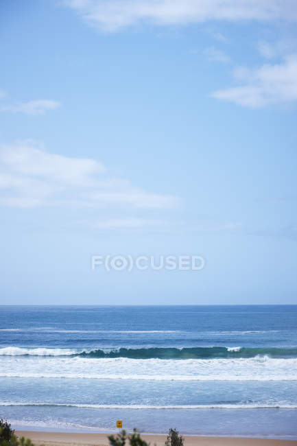 Плещущиеся волны на береговой линии с пляжа — стоковое фото