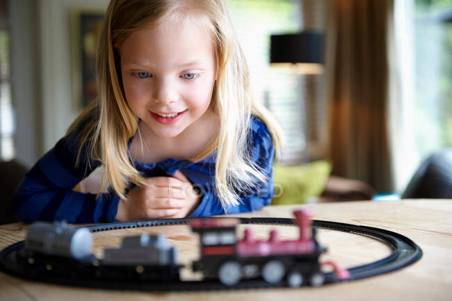 Juego femenino con tren de juguete - foto de stock