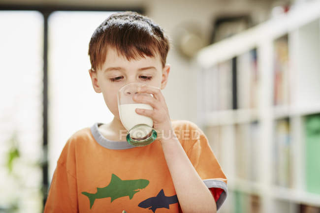 Jovem menino bebendo copo de leite — Fotografia de Stock