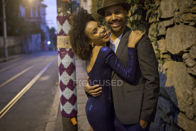 Portrait of couple hugging in street at night — Stock Photo