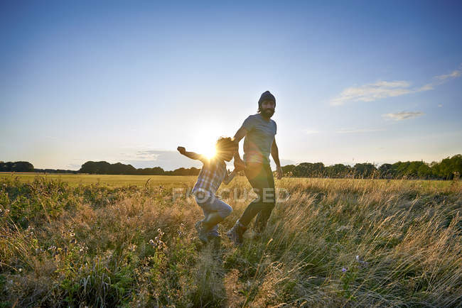 Padre e hijo caminando en el campo del parque - foto de stock