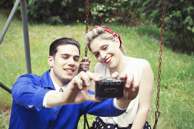 Jeune couple vintage prenant selfie dans le jardin — Photo de stock