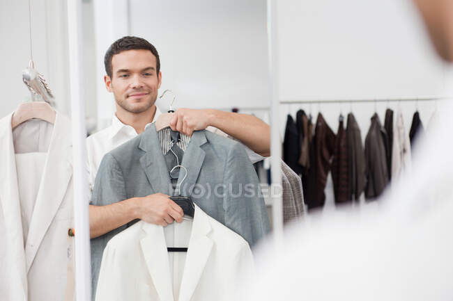 Mann beim Einkaufen hält Jacke hoch — Stockfoto