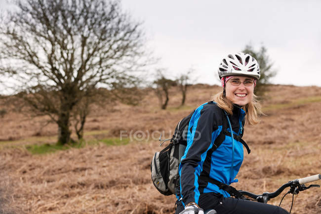 Mulher com bicicleta no campo — Fotografia de Stock