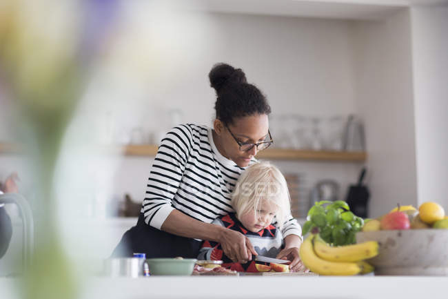 Mãe ajudando filho preparar comida na cozinha — Fotografia de Stock
