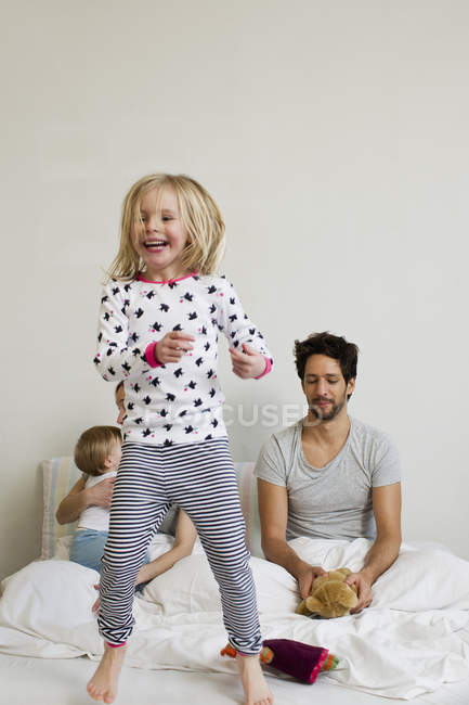 Little girl jumping on  parents bed — Stock Photo