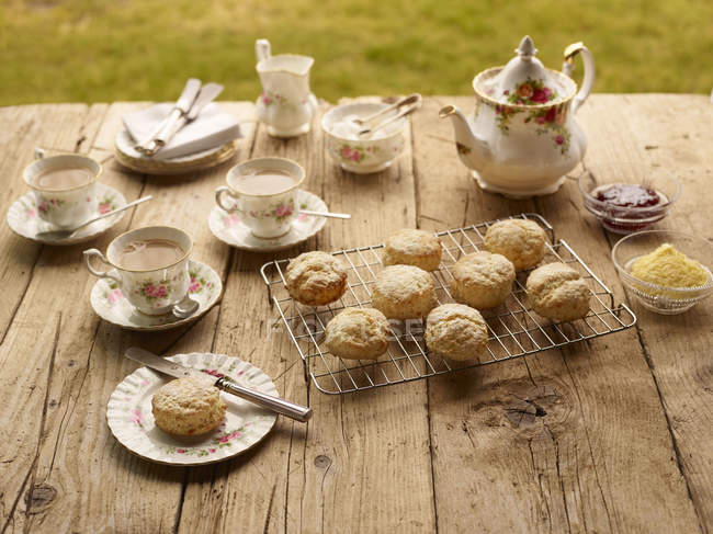 Table avec thé de l'après-midi de scones frais cuits au four — Photo de stock