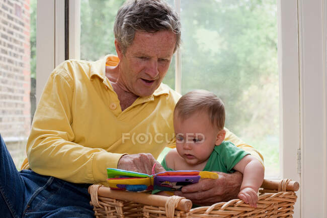 Opa liest Enkel eine Geschichte vor — Stockfoto