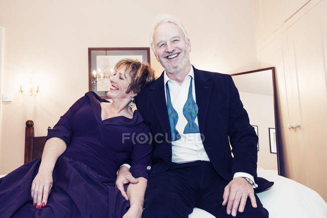 Paar lacht und sitzt zu Hause im Bett — Stockfoto